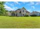 Expansive backyard view of a two-story home with a large lawn at 164 Gleneagles Way, Fayetteville, GA 30215
