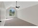 Large bedroom with vaulted ceiling, neutral carpet, fan, and a large arched window at 164 Gleneagles Way, Fayetteville, GA 30215