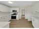 Well-lit kitchen with stainless steel appliances, light wood flooring, and white cabinets at 164 Gleneagles Way, Fayetteville, GA 30215