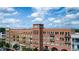 Multi-story building with brick and tan facades featuring private balconies on a partly cloudy day at 360 Chambers St # 405, Woodstock, GA 30188