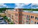 Multi-story brick building featuring private balconies and various storefronts on a partly cloudy day at 360 Chambers St # 405, Woodstock, GA 30188