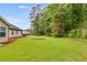 Exterior view of backyard featuring a large manicured yard and mature trees at 4490 Epworth Court Ct, Powder Springs, GA 30127