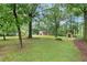 Large, green backyard with mature trees and outbuildings offers privacy and outdoor space at 48 Saddle Field Nw Cir, Cartersville, GA 30121