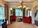 Cozy living area with large windows, stylish chandelier, and comfortable red seating at 520 Harmony Way, Locust Grove, GA 30248
