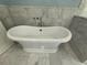 Freestanding tub inside a bathroom featuring marble floors and walls at 722 Beauregard Sw Dr, Marietta, GA 30064