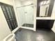 Modern bathroom features a glass enclosed shower, dark cabinetry, and stylish hexagonal tile flooring at 722 Beauregard Sw Dr, Marietta, GA 30064