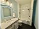 Charming bathroom featuring marble vanity, tub with tile surround, and unique mirror at 722 Beauregard Sw Dr, Marietta, GA 30064