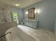 Bright bathroom featuring a soaking tub, marble floors, a vanity with mirror, and a separate shower area at 722 Beauregard Sw Dr, Marietta, GA 30064