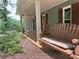 Charming front porch featuring a wooden swing, wood siding, and stone pavers at 722 Beauregard Sw Dr, Marietta, GA 30064