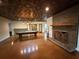 Spacious game room with pool table, brick fireplace, and unique decorative ceiling tiles at 722 Beauregard Sw Dr, Marietta, GA 30064