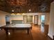 Spacious game room featuring a pool table and unique, decorative tin ceiling design and hardwood floors at 722 Beauregard Sw Dr, Marietta, GA 30064