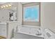 Bright bathroom with a garden tub and a window offering natural light at 920 Highfield Ct, Lawrenceville, GA 30043