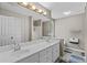 Bathroom featuring double sinks, a vanity with white cabinets, and a separate shower at 920 Highfield Ct, Lawrenceville, GA 30043