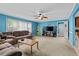 Comfortable living room featuring blue walls and a ceiling fan with ample seating, perfect for Gathering gatherings at 920 Highfield Ct, Lawrenceville, GA 30043
