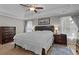 Comfortable main bedroom featuring a tray ceiling, a large bed, and stylish wood furniture at 920 Highfield Ct, Lawrenceville, GA 30043