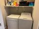 Functional laundry area with washer, dryer, and storage shelves for cleaning supplies at 1130 Weatherstone Ne Dr, Atlanta, GA 30324