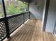 Private patio area with wood flooring and lattice railing overlooking greenery at 1130 Weatherstone Ne Dr, Atlanta, GA 30324