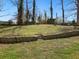 Backyard featuring a sloped yard of green grass, a rock retaining wall and some steps at 1406 Kennesaw Nw Dr, Atlanta, GA 30318