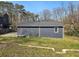 Backyard featuring a dark blue house with light trim and a sloped yard of green grass at 1406 Kennesaw Nw Dr, Atlanta, GA 30318