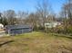 Backyard featuring a dark blue house with light trim and a sloped yard of green grass at 1406 Kennesaw Nw Dr, Atlanta, GA 30318