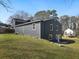 Backyard featuring a dark blue house with light trim and a sloped yard of green grass at 1406 Kennesaw Nw Dr, Atlanta, GA 30318