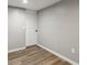 Unfinished basement featuring wood-look vinyl flooring, light-grey walls, and a door at 1406 Kennesaw Nw Dr, Atlanta, GA 30318
