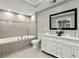 Modern bathroom features dual vanity, soaking tub, and tiled walls with a large framed mirror at 1406 Kennesaw Nw Dr, Atlanta, GA 30318