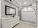 Modern bathroom with dual vanity, shower with tiled walls, and neutral colors and a large framed mirror at 1406 Kennesaw Nw Dr, Atlanta, GA 30318