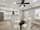 Stylish dining room with modern lighting, ceiling fan, glass table, and white chairs at 1406 Kennesaw Nw Dr, Atlanta, GA 30318