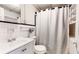 Standard bathroom featuring a shower with curtain and a white sink, toilet and shelving at 147 Olympic Pl, Decatur, GA 30030