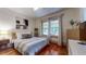Cozy bedroom featuring hardwood floors, large window, and stylish modern decor at 147 Olympic Pl, Decatur, GA 30030