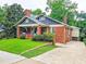 Classic brick home with inviting front porch, mature trees, and a convenient driveway at 147 Olympic Pl, Decatur, GA 30030