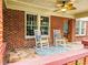 Inviting front porch with stone floor, rocking chairs, brick columns, and decorative glass door at 147 Olympic Pl, Decatur, GA 30030