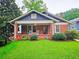 Charming brick home with a cozy front porch featuring rocking chairs and lush green landscaping at 147 Olympic Pl, Decatur, GA 30030