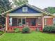 Charming brick home with a cozy front porch featuring rocking chairs and lush green landscaping at 147 Olympic Pl, Decatur, GA 30030