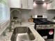 Close up of the sink, faucet, granite countertops, and stainless steel oven in this kitchen at 2107 Garden Cir, Decatur, GA 30032