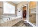 Luxurious bathroom featuring a soaking tub, walk-in shower, and stylish tilework leading to a walk-in closet at 1997 Shaker Falls Ln, Lawrenceville, GA 30045