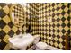 Unique powder room featuring bold black and gold wallpaper and a pedestal sink at 1997 Shaker Falls Ln, Lawrenceville, GA 30045
