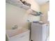 Clean laundry room with a deep sink, modern washer and dryer, and storage shelves at 1997 Shaker Falls Ln, Lawrenceville, GA 30045
