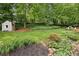 Spacious backyard featuring a storage shed, lush lawn, and a rock garden at 2481 Melinda Ne Dr, Atlanta, GA 30345