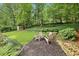 Backyard firepit area with Adirondack chairs, lush greenery, and a storage shed at 2481 Melinda Ne Dr, Atlanta, GA 30345