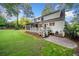 Expansive backyard with a well-maintained lawn, wooden deck, and steps to a stone patio at 4333 Collingham Ne Trce, Marietta, GA 30068