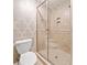 Tiled walk-in shower with glass doors in a bathroom, complimented by neutral patterned wallpaper at 4333 Collingham Ne Trce, Marietta, GA 30068