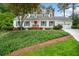 Charming home featuring a red door, dormer windows, beautiful landscaping, and a two-car garage at 4333 Collingham Ne Trce, Marietta, GA 30068