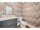 Elegant powder room with chevron wallpaper, marble countertop, and gold fixtures create a stylish design at 4333 Collingham Ne Trce, Marietta, GA 30068
