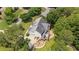 Aerial perspective of home featuring a deck, stone patio with fire pit, and lush landscaping for outdoor living at 735 River Ridge Ln, Suwanee, GA 30024