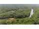 A scenic aerial view showcasing homes nestled among dense, mature trees and a river at 735 River Ridge Ln, Suwanee, GA 30024