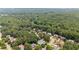 This aerial view shows a neighborhood with lovely homes surrounded by mature trees at 735 River Ridge Ln, Suwanee, GA 30024