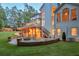 Spacious backyard featuring a stone patio with a fire pit, a covered deck, and lush landscaping for outdoor enjoyment at 735 River Ridge Ln, Suwanee, GA 30024
