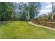 Well-maintained backyard with a manicured lawn, landscaping, and a walkway at 735 River Ridge Ln, Suwanee, GA 30024